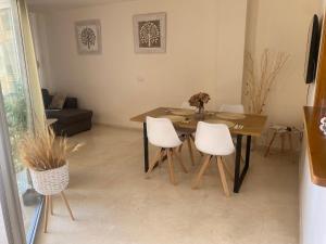 uma sala de jantar com uma mesa e cadeiras brancas em Apartamento Alcotan em Cala de Finestrat