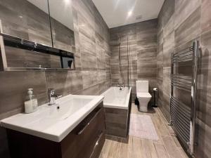 a bathroom with a sink and a toilet at Star London Finchley Road 3-Bed Oasis with Garden in London