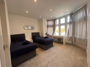 1 Schlafzimmer mit 2 Betten und einem Fenster in der Unterkunft Star London Finchley Road 3-Bed Oasis with Garden in London