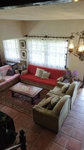 a living room with couches and a red couch at Sitio três porteiras in Paty do Alferes