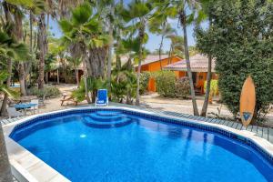 a swimming pool in front of a house with palm trees at Tropical Divers Resort in Kralendijk