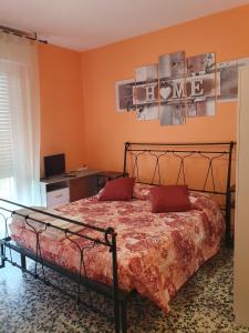 - une chambre avec un lit aux murs orange et un bureau dans l'établissement Andrea affittacamere e B&B, à Solignano Nuovo