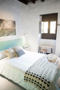 een slaapkamer met een groot wit bed en een raam bij Casa El Terrero in Gáldar