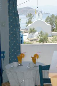 una mesa con dos tazas y naranjas. en Athina Apartments Naxos Town, en Naxos Chora