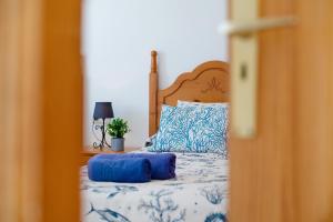 a bed with blue and white sheets and pillows at Callao Beach 9 in Arrieta