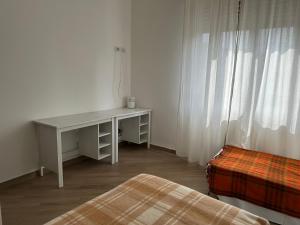 einen weißen Schreibtisch in einem Zimmer mit einem Bett in der Unterkunft Appartamento via centro in Verona