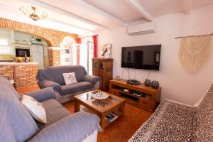 a living room with a couch and a tv at Villa Es Cuco in Port des Torrent