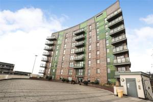 a large apartment building with a large parking lot at Chic Leeds City Apartment, Free Parking, Balcony in Leeds