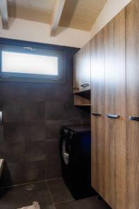 a bathroom with a washing machine and a wooden cabinet at Inalia Modern House in Lefkimmi +19 photos