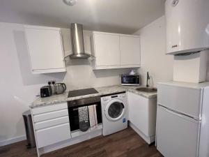 a kitchen with a washing machine and a washer at Star London Vivian Avenue 1-Bed Hideaway with Garden in Hendon