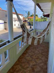 a hammock on the porch of a house at Casinha Valdenia: No paraíso com Wi-Fi, em Mundaú in Trairi