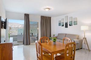 een eetkamer en een woonkamer met een tafel en stoelen bij Callao Beach 5 in Arrieta