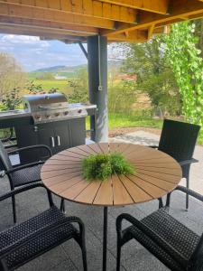 una mesa y sillas en un patio con parrilla en Glamping Holiday House with hot tub and sauna- Hisa oddiha, en Smarjeske Toplice