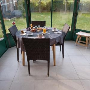 - une table à manger avec des chaises et de la nourriture dans l'établissement Plage du Pont - Chambres d'Hôtes, à Saint-Malo