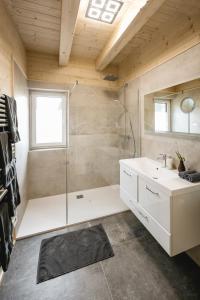 ein Badezimmer mit einer Dusche, einer Badewanne und einem Waschbecken in der Unterkunft Chalet 49 Nesselgraben - Ferienwohnungen aus Holz in Koppl