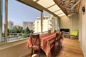 a balcony with a table and chairs and a window at Beautiful 3 room apartment with air-conditioned loggia close to the Croiset in Cannes