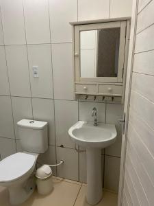 a bathroom with a toilet and a sink and a mirror at Casinha Valdenia: No paraíso com Wi-Fi, em Mundaú in Trairi