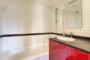 La salle de bains est pourvue d'un lavabo, d'une douche et d'une baignoire. dans l'établissement Beautiful 3 room apartment with air-conditioned loggia close to the Croiset, à Cannes