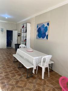 una mesa y 2 sillas blancas en una habitación en Casinha Valdenia: No paraíso com Wi-Fi, em Mundaú, en Trairi