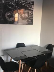 a black table with chairs and a picture of a motorcycle at Appart douillet Paris 11 in Paris