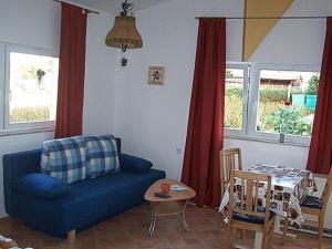 a living room with a blue couch and a table at FeWo Ruppel in Driedorf
