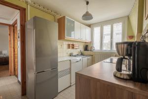 a kitchen with a stainless steel refrigerator and white cabinets at Calme et lumière à proximité de la Vieille Ville de Boulogne sur mer in Boulogne-sur-Mer