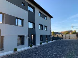 a white building with a driveway in front of it at Wonderland apartment in Bistriţa