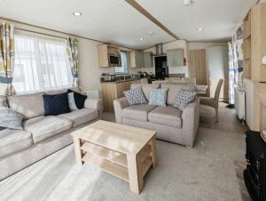 a living room with two couches and a table at Primrose - 3 bedroom luxury lodge in South Cerney