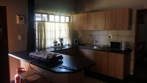 een keuken met een aanrecht en een magnetron bij Skillie lodge in Sodwana Bay