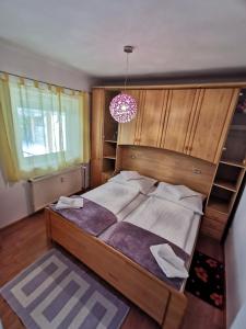 a bedroom with a large bed and a chandelier at Landhaus Forrás 2 in Balatonfüred