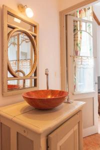 La salle de bains est pourvue d'un lavabo en bois et d'un miroir. dans l'établissement Maison le Village - Maison d’Hôtes, à Montagny-lès-Beaune