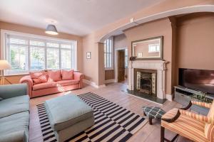 a living room with pink furniture and a fireplace at Hillcrest, Aldeburgh in Aldeburgh