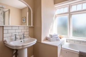 a white bathroom with a sink and a window at Hillcrest, Aldeburgh in Aldeburgh +37 photos