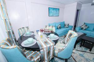 sala de estar con mesa y sofá azul en Atlantic House 3 Bedroom, Naivasha, en Naivasha