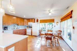 a kitchen with a table and chairs and white appliances at Captain's Choice 360 in Frisco +18 photos