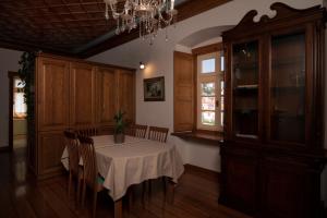 a dining room with a table and chairs and a chandelier at Antoinette Mansion in Hydra