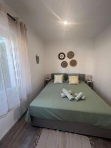 - une chambre avec un lit vert et 2 oreillers dans l'établissement "Le nature" Camargue Jardin, à Arles