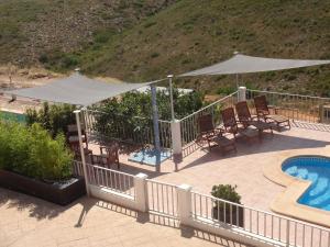a patio with a pool and an umbrella and chairs and a swimming pool at LAS PALOMAS, appartement 3 chambres avec piscine in Turís