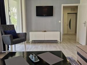 a living room with a chair and a tv on the wall at VIEW APARTMENT in Visoko