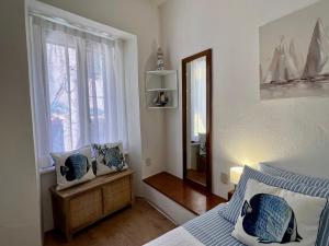 a bedroom with a bed and a mirror and a window at NUOVO Luminoso a 100 passi dalla piazza in Rio nellʼElba