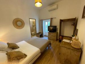 - une chambre avec un grand lit et une télévision dans l'établissement Hotel Mas De Galoffre, à Nîmes