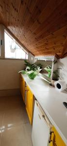 a kitchen with yellow cabinets and a wooden ceiling at Tirana Central GuestHouse in Tirana