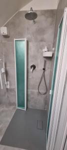 La salle de bains est pourvue d'une douche avec une porte en verre. dans l'établissement La Cameretta al Porto, à Ischia