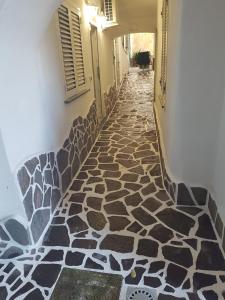 un corridoio con pavimento piastrellato in un edificio di La Cameretta al Porto a Ischia