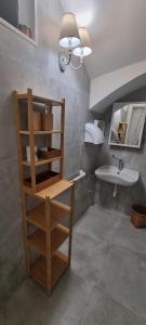 a bathroom with a sink and a shelf and a mirror at La Cameretta al Porto in Ischia