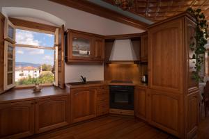 una cocina con armarios de madera y una ventana en Antoinette Mansion en Hydra