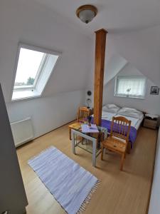 um quarto com uma cama, uma mesa e 2 cadeiras em Landhaus Forrás 2 em Balatonfüred