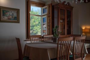 jadalnia ze stołem i krzesłami oraz oknem w obiekcie Antoinette Mansion w mieście Hydra