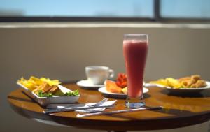 - une table avec une boisson et des assiettes de nourriture dans l'établissement Hotel Sicarare, à Valledupar