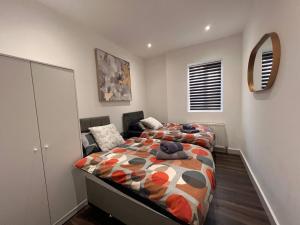 een slaapkamer met 2 bedden en een stoel. bij Star London Finchley Road 3-Bed Escape with Garden in Londen